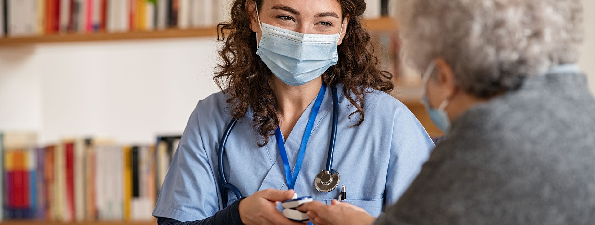 Doctor examining senior woman using oximeter at home. 