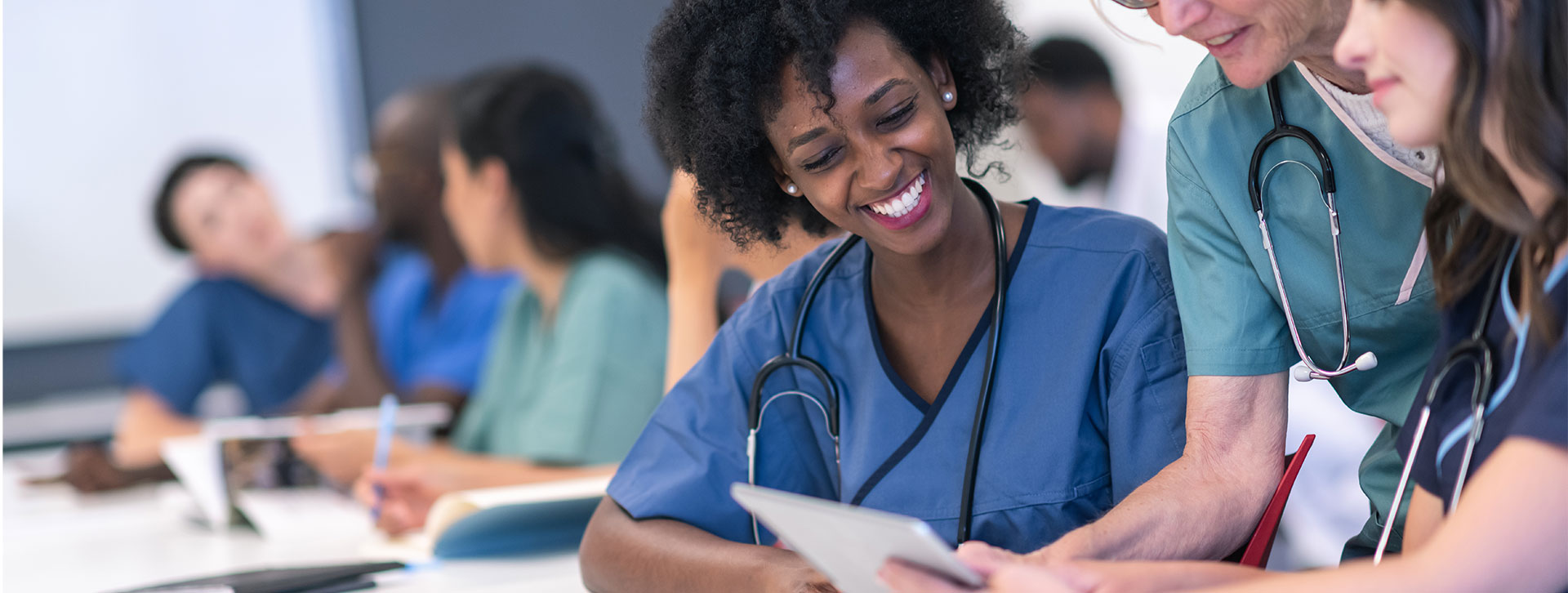 Senior female lecturer assists medical students during class.