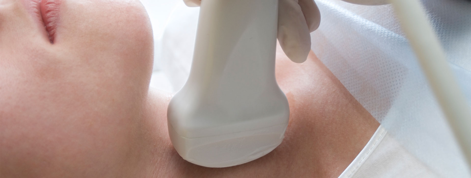 Woman having her neck scanned with ultrasound.