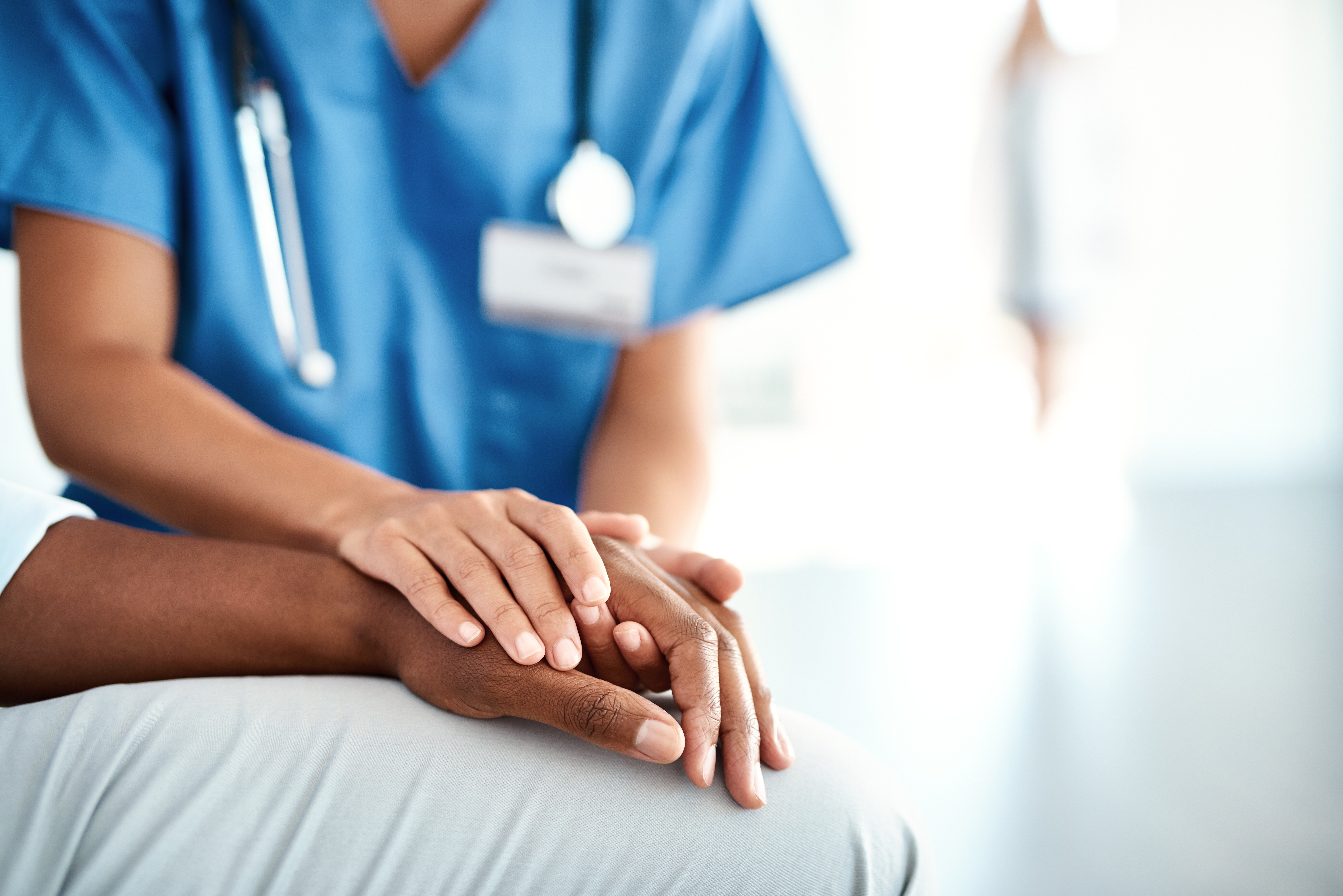 Doctor holding hands with patient