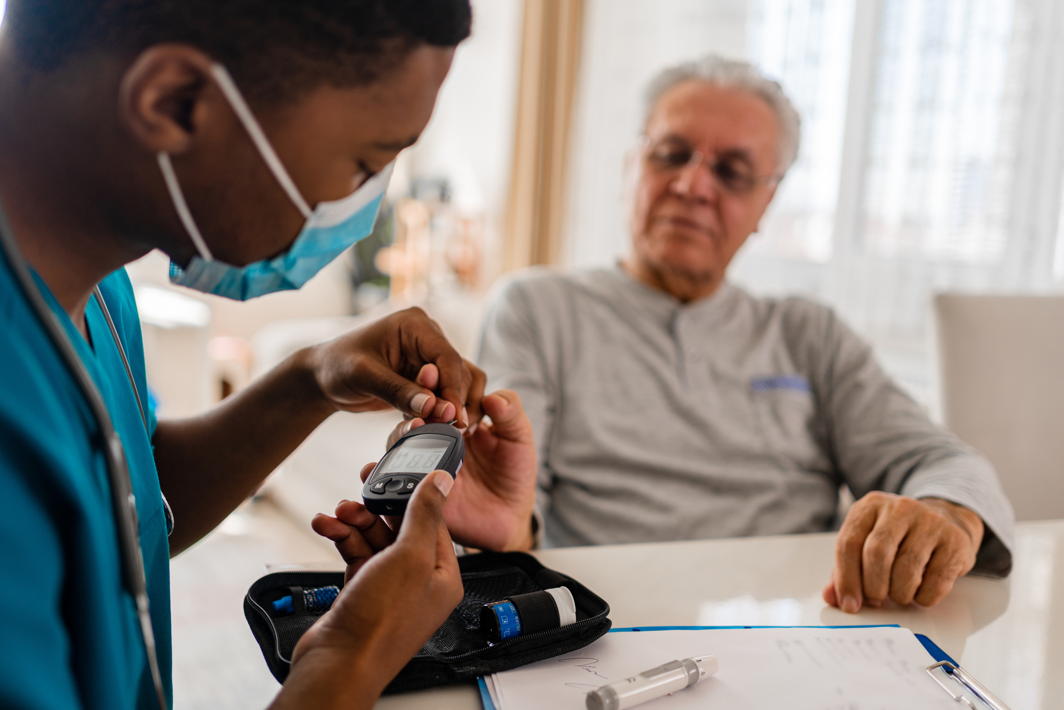 District male nurse at home visit - stock photo