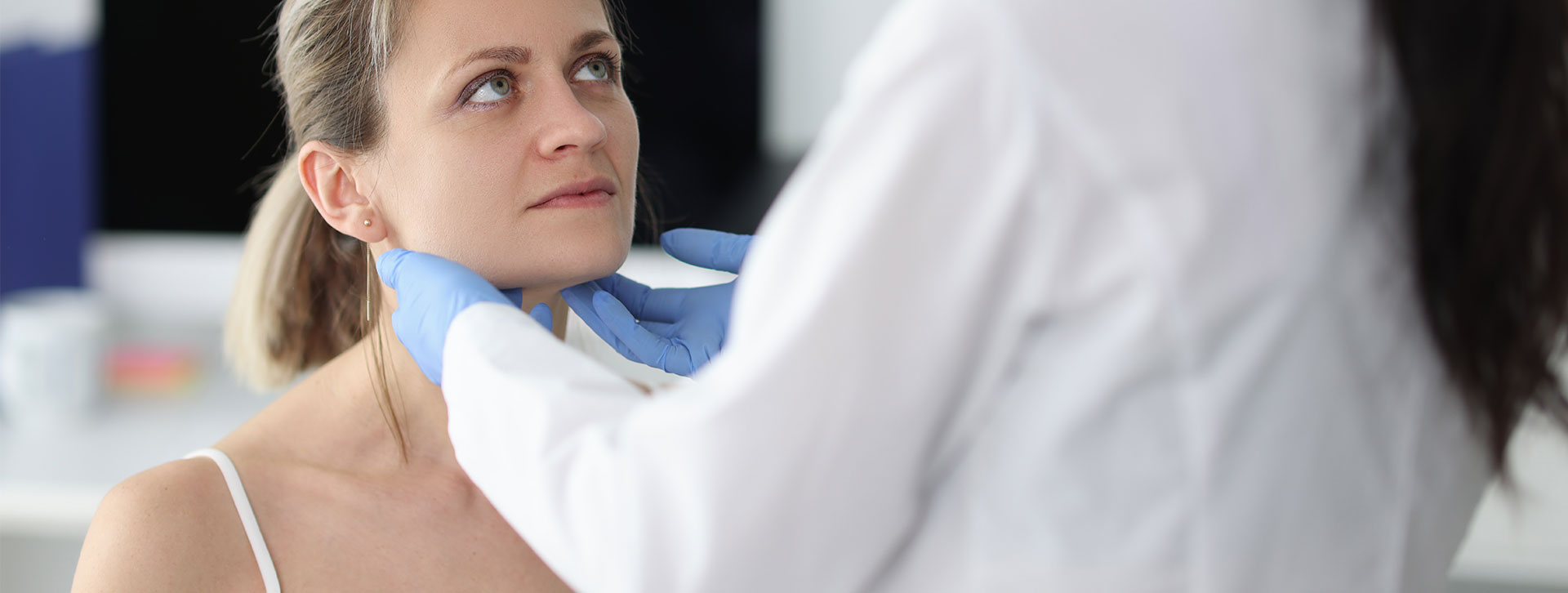 Doctor examining patients submandibular lymph nodes in clinic