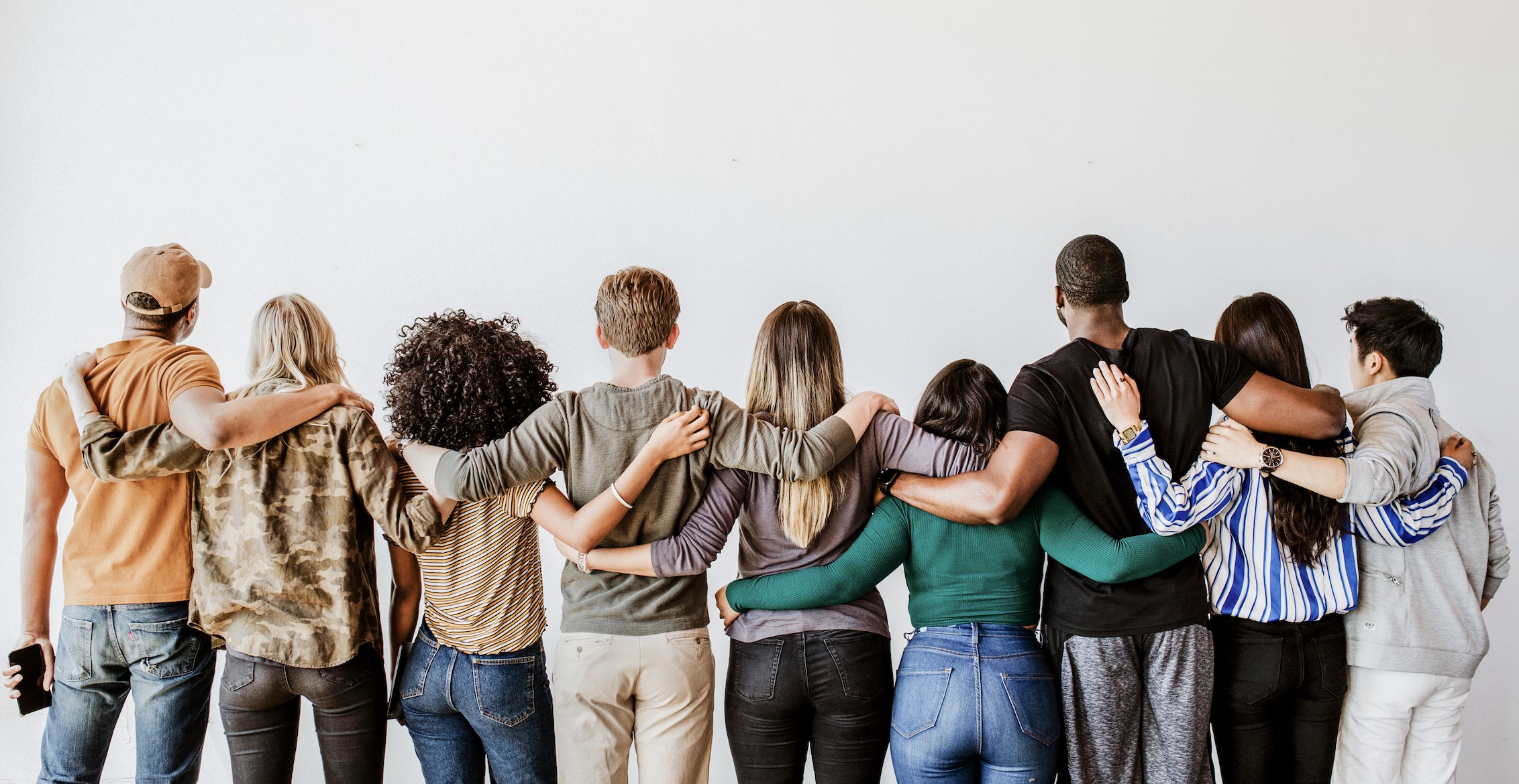 A group of people with their arms around another in a line. 