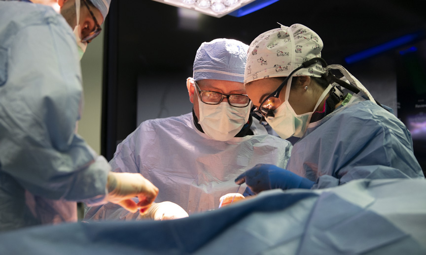 Image of a male and female physician performing surgery.