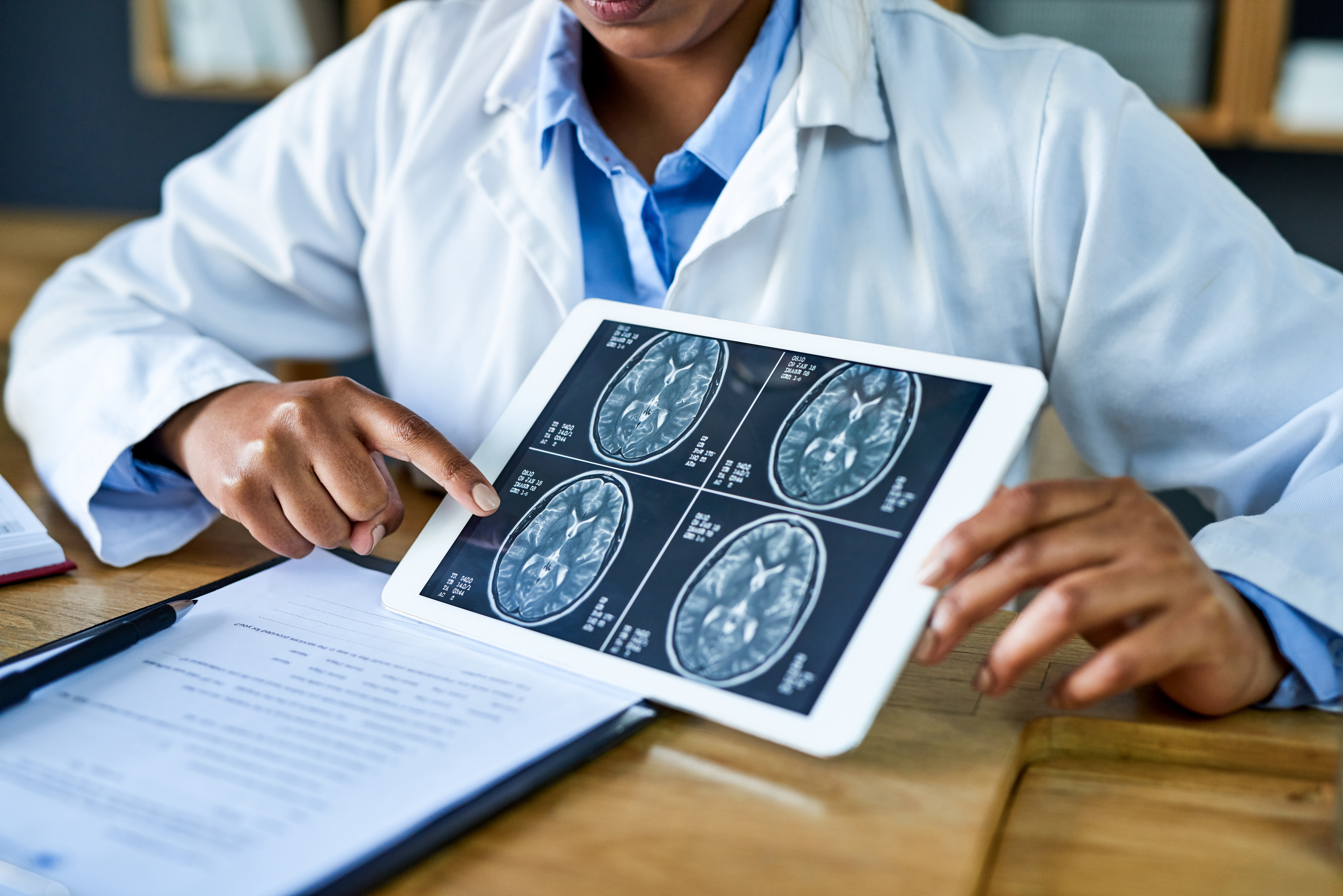 Shot of a doctor using a digital tablet to discuss a brain scan during a consultation in her office.