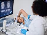 Woman receiving a breast cancer screening and a doctor looking over the results.