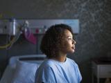 female sitting on hospital bed.