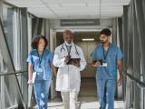 three doctors walking in a hallway.