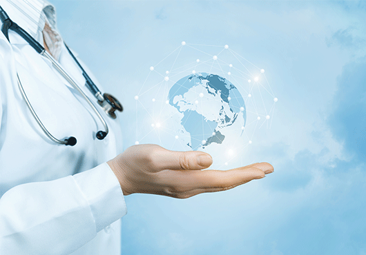 A female doctor with a stethoscope on her neck is holding a crystal, sparkling global map on her hand 