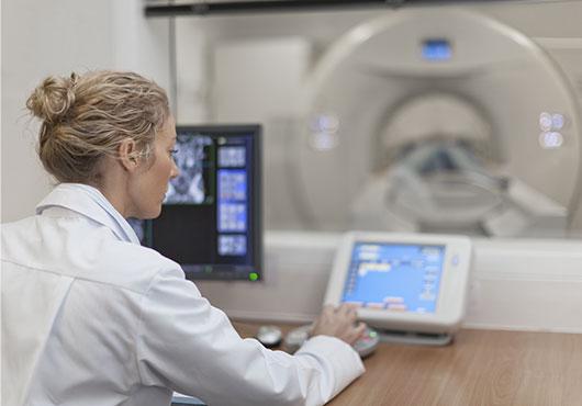 Doctor operating CT scanner in hospital 