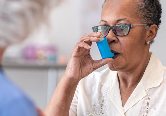 Women using inhaler.