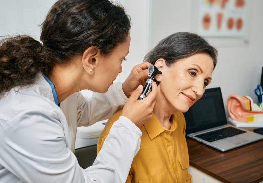 Female doctor performing routine exam on senior patient.