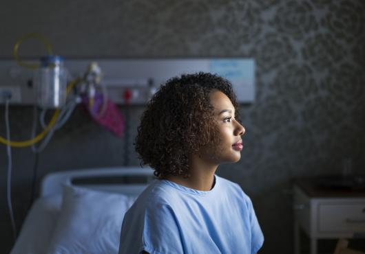 female sitting on hospital bed.