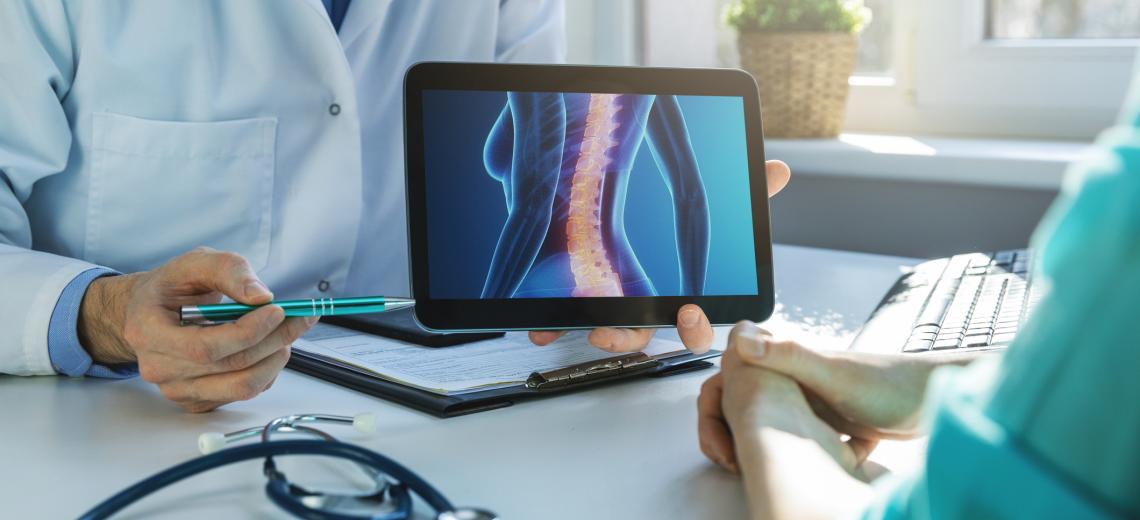 Doctor showing patient an x-ray of their spine.