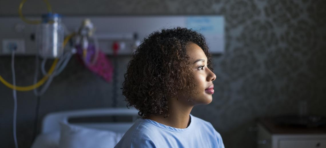 female sitting on hospital bed.