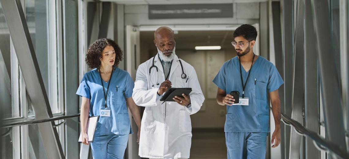 three doctors walking in a hallway.